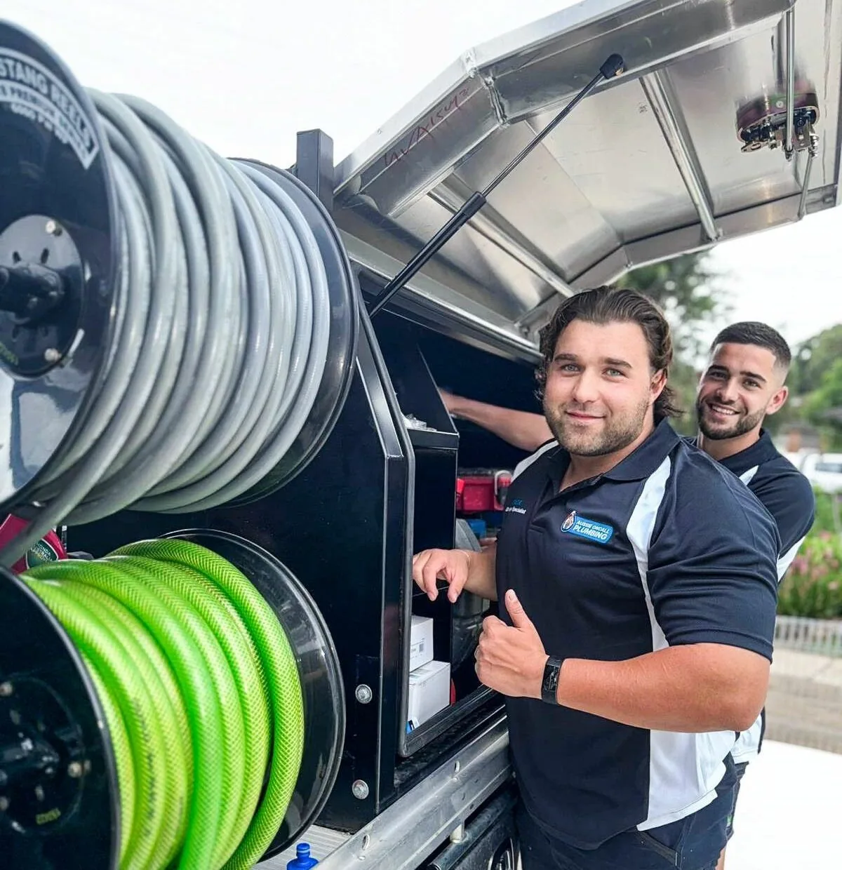 Zack, owner of Aussie Oncall Plumbing & Drains, at the service van with a team member